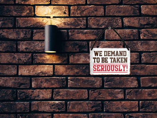 Tin sign ''We demand to be taken seriously'' 18x12cm